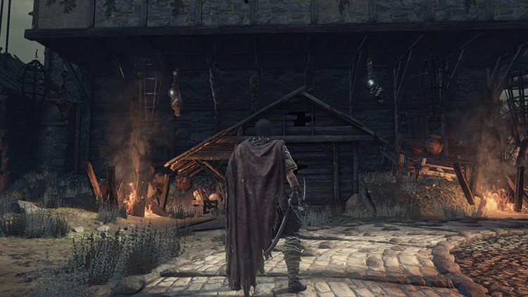 Corpses hanging from the large building behind the fires / Dark Souls 3