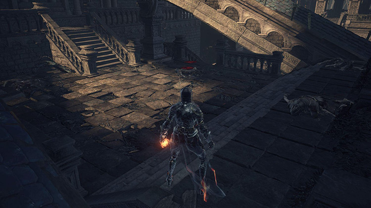 The courtyard at the bottom of the ramp. The way forward is straight ahead, marked by blood stains. / Dark Souls 3