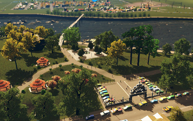 A park area that goes across the river isn’t just pretty, but also serves as a popular pedestrian path that can earn you a nice bit of extra money. / Cities: Skylines